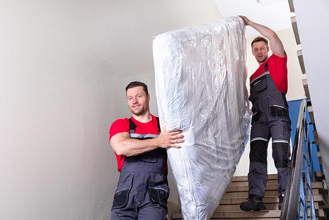 two people loading a box spring into a truck in Kenilworth